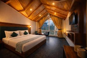 a bedroom with a bed and a large window at Avasa Boutique Hotel Manali in Manāli