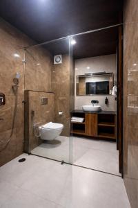 a bathroom with a shower and a toilet and a sink at Avasa Boutique Hotel Manali in Manāli