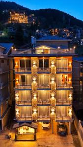 a building with cars parked outside of it at night at Avasa Boutique Hotel Manali in Manāli
