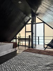 a bedroom with a bed and a view of the ocean at Cabañas La PetiteChef in El Limar