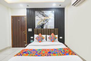 a bedroom with a large bed with colorful pillows at FabHotel Samarth Residency By the Arrow in New Delhi +27 photos