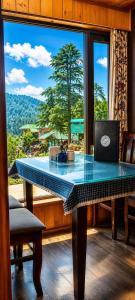 a table with a laptop on it in front of a window at Pine view in Gulmarg +38 photos