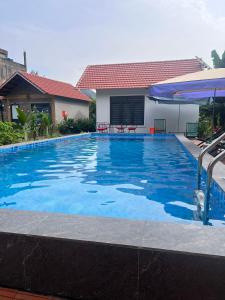 a large blue swimming pool in front of a house at Tam Coc Mountain Light Homestay in Ninh Binh