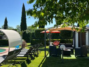 a patio with a table and chairs under an umbrella at RelaxHomeHoliday in Panicale