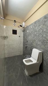 a bathroom with a toilet and a shower at New Castle Residency in Cochin +12 photos