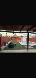 a patio with a table and an umbrella and a pool at Cabaña Kuarahy in Empedrado