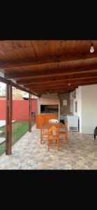 a patio with two benches and a table and a kitchen at Cabaña Kuarahy in Empedrado