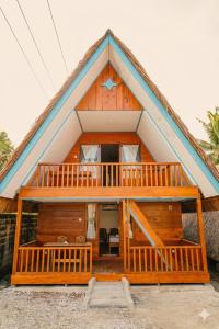 a large wooden house with a large deck at Baruk Homestay in Katiet