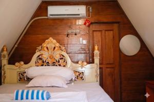 a bedroom with a bed with a wooden headboard at Baruk Homestay in Katiet +11 photos