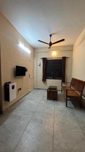 a living room with a ceiling fan and a couch at New Castle Residency in Cochin