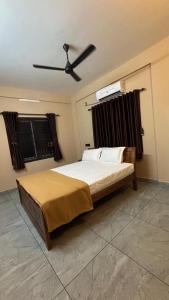 a bedroom with a bed with a ceiling fan at New Castle Residency in Cochin