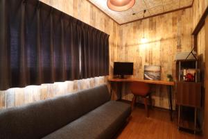 a living room with a couch and a desk with a computer at Casa di acero in Kikuchi