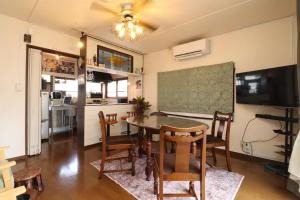 a dining room with a table and chairs and a chalkboard at Casa di acero in Kikuchi