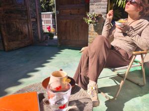 a woman is sitting in a chair with a drink at October Inn in Lijiang