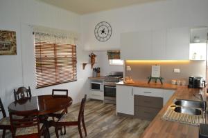 a kitchen with a table and a dining room at Cherry Blossom Cottage-with country charm and spa in Stanthorpe