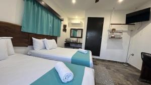 a hotel room with two beds and a television at Hotel y Beach Club Casa Mia Xulha -Bacalar in Xul-Ha