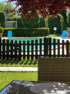 a black fence with two blue chairs in a park at RelaxHomeHoliday in Panicale