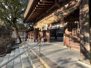 a building with people sitting outside of it at Casa di acero in Kikuchi