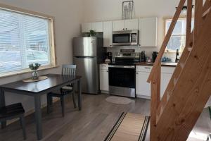 a kitchen with a table and a stainless steel refrigerator at Seward Mountain View Cabins #6 in Seward