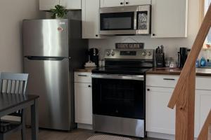 a kitchen with a stainless steel refrigerator and a stove at Seward Mountain View Cabins #6 in Seward
