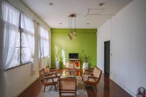 a living room with chairs and a table and a television at DoubleTree House in Chiang Mai