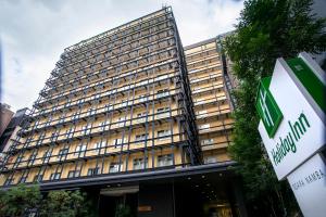 a tall building with a sign in front of it at Holiday Inn Osaka Namba by IHG in Osaka
