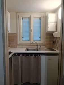 a kitchen with a sink and two windows at Liberty 21 in Andria