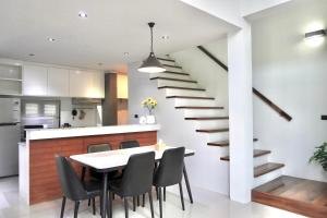 a kitchen and dining room with a staircase and a table and chairs at Ana's House in Nathon Bay