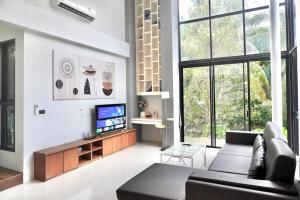 a living room with a couch and a tv at Ana's House in Nathon Bay