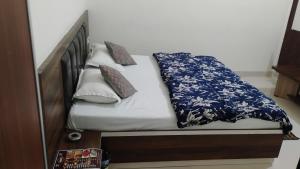 a bed with a blue and white blanket and pillows at SR Resort Ateli in Ateli