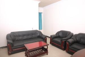 two leather couches and a coffee table in a living room at Sai Kirshanth Residency in Karaikal