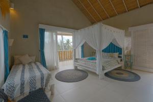 a bedroom with two beds and a canopy bed at Coco Verde Bali Resort in Tanah Lot +39 photos
