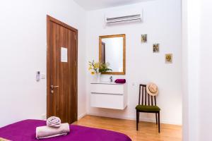 a bedroom with a purple bed and a mirror at Marco Polo Party Hostel in St. Julianʼs