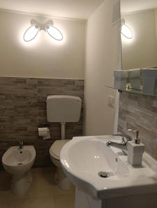 a bathroom with a sink and a toilet and a mirror at Liberty 21 in Andria