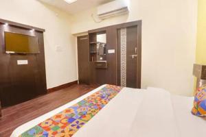 a hotel room with a bed and a bathroom at FabHotel Ambika Dx in Gwalior