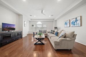 a living room with a couch and a flat screen tv at Houston Lake Retreat Pool Lake Front Spa in Humble