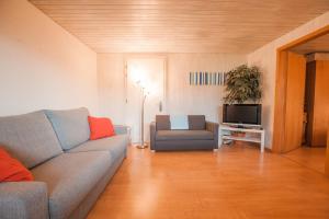 a living room with a couch and a chair at apartment Monte Castello in Wolhusen