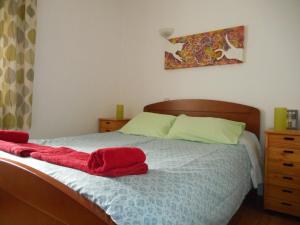 een slaapkamer met een bed met rode handdoeken erop bij Vista da Marina in Lagos