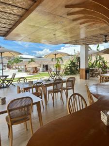 a restaurant with tables and chairs and umbrellas at Beyond Island Resort in Moalboal