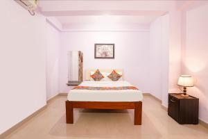 a white bedroom with a bed and a lamp at FabHotel Shadowline in Goa +46 photos