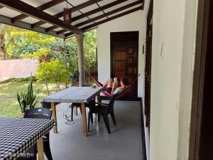 a woman laying in a hammock on the porch of a house at The Onisula Guest House in Ahangama