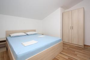 a bedroom with a bed and a cabinet at Apartmani Ruža in Novalja