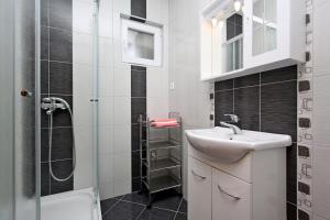 a small bathroom with a sink and a shower at Apartmani Ruža in Novalja