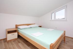 a white room with a bed and a window at Apartmani Ruža in Novalja