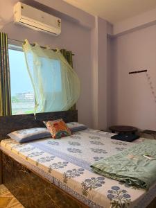 a bed in a room with a window and a bedvisor at Windchime 9 in Guwahati