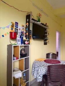 a room with a table and a tv on the wall at Windchime 9 in Guwahati