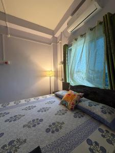 a bedroom with a bed with a pillow and a window at Windchime 9 in Guwahati