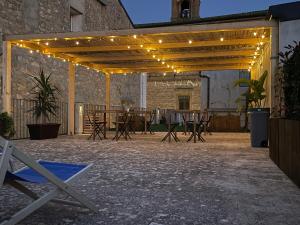 a patio with a table and chairs and lights at Camurria Sicilian B&B in Piazza Armerina