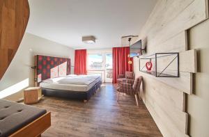 pokój hotelowy z łóżkiem i krzesłem w obiekcie Hotel Alpenblick w Saalbach Hinterglemm