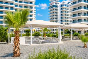 a palm tree and umbrellas in front of a building at Caesar Blue Collection Nothern Cyprus Studios & Spa Resort in Kaimakli